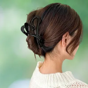 Elegant black heart hair claw clip for women's daily bun hairstyles on a model