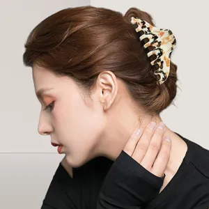 Large irregular speckled hair claw clip with tortoise pattern on Asian model side view