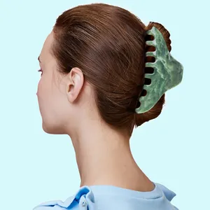 Green marble pattern hair claw clip securing a ponytail on a woman, back view shot