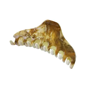 Macro detail of large crescent hair claw with vintage tortoiseshell marble patterns