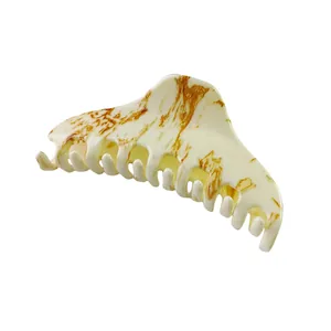 Detail view of large marble texture hair claw clip in cream with brown spots finish