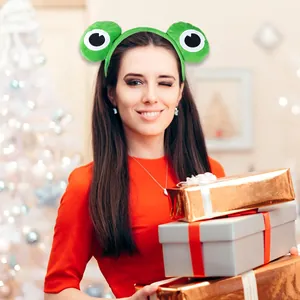 Detail of green frog plush headband with large eyes on model during Christmas