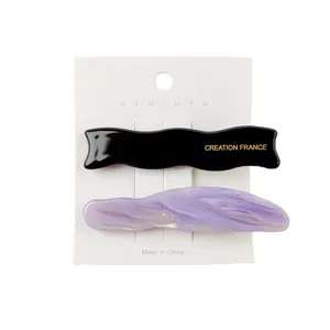 Detailed set of acetate hair clips featuring black wave and lilac marble patterns on a card