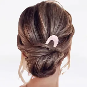 Pink minimalist U-shaped resin hair fork pin shown on a bun for elegant hairstyling