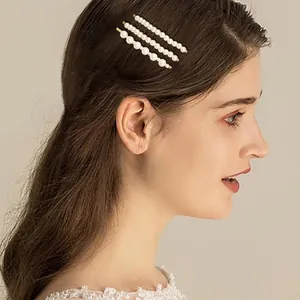 Elegante set di tre fermagli per capelli con perle dorate indossati da una modella