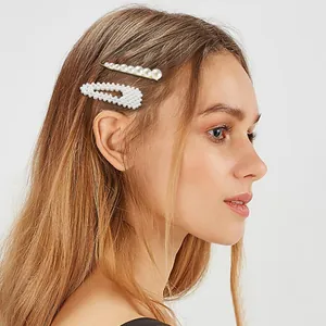 Elegante set di due fermagli per capelli con perle bianche e base in metallo dorato lucido