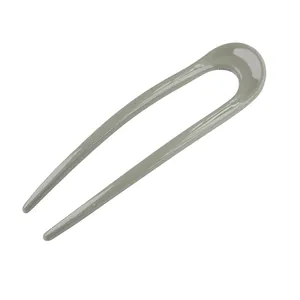 Close-up of a glossy khaki green U-shaped hair pin for elegant bun hair styling