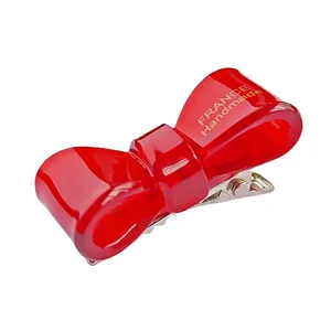 Barrette à nœud rouge en acétate avec inscription dorée France Handmade sur pince crocodile