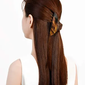 Detailed back view of a dark brown tortoiseshell hair claw clip securing a low ponytail