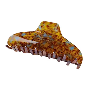 Macro shot of large acetate hair claw with vintage tortoiseshell texture and blue accents