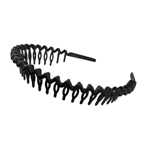 Detail of matte black wavy headband featuring non-slip comb teeth on white background