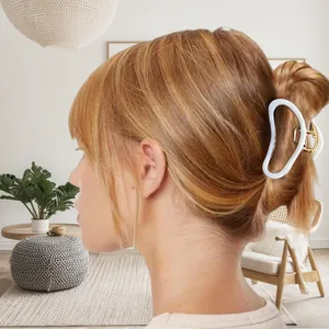 Pince à cheveux élégante en métal doré avec motif géométrique blanc sur le modèle