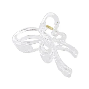 Detail view of transparent butterfly hair claw clip with golden metal spring and drip oil finish