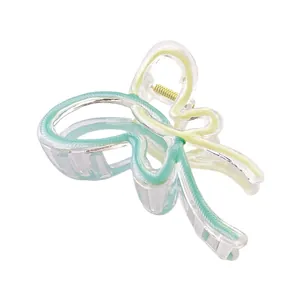 Detail of butterfly hair claw with mint green gradient and gold spring on white background