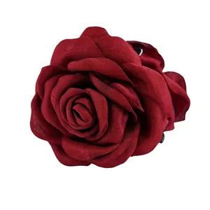 Vue détaillée de la texture des pétales de rose en tissu rouge foncé de cette pince