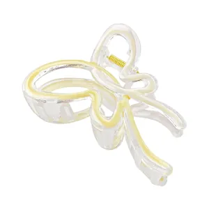Macro detail of butterfly hair claw clip with yellow swirl texture and gold metal spring