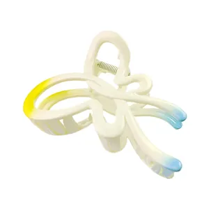 Detail view of a large butterfly hair claw with yellow and blue gradient on white acrylic