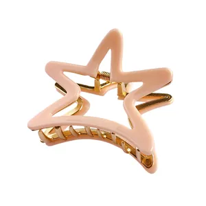 Detailansicht der rosa Stern-Haarklammer mit goldener Metallfeder und glatter Oberfläche