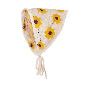Detail van gehaakte driehoekige hoofddoek met madeliefjes en gebreide textuur