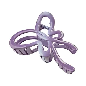 Macro detail of purple butterfly hair claw clip with metallic finish and spring