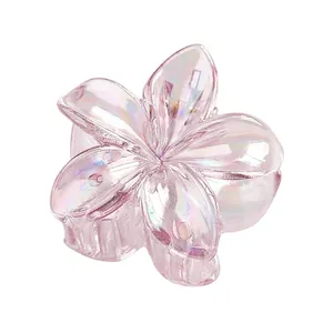 Détail d'une pince à cheveux fleur rose irisée avec pétales 3D et fini nacré