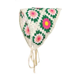 Detail van gehaakte driehoekige bandana met madeliefjespatroon en gebreide bandjes