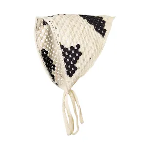 Detailopname van de crème gehaakte driehoekige hoofddoek met zwarte gebreide bloemen