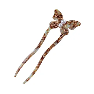 U-shaped butterfly hair pin with amber tortoise shell pattern and pearl accents