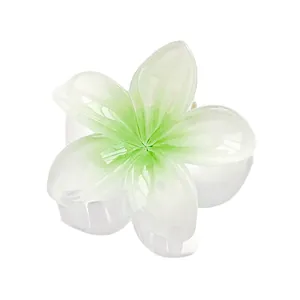 Detail van een 4 cm groene en witte plumeria haarklem met een glanzende jelly afwerking