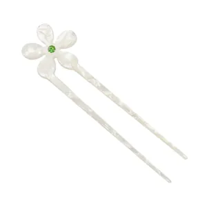 Detail view of U-shaped hair pin with cream floral motif and green gemstone center