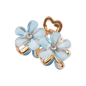 Détails de fleurs en résine bleue avec strass étincelants sur pince à cheveux dorée