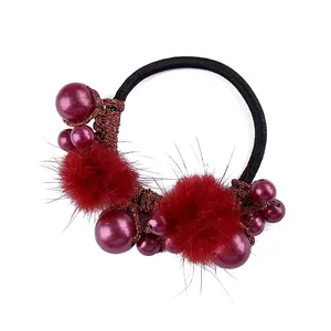Detailed view of burgundy pompom and pearl elastic hair tie for elegant ponytail styling