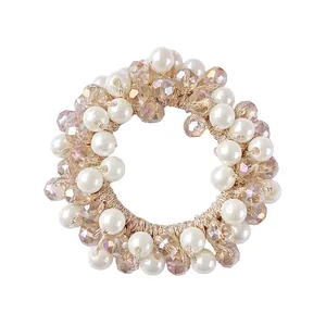 Close-up of champagne elastic hair tie with white pearls and faceted crystal beads