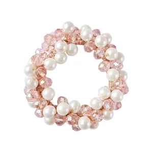 Elastic hair tie featuring white pearls and pink faceted beads with gold woven cord