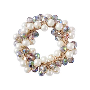 Detailed shot of pearl and faceted crystal beads woven on an elastic hair tie