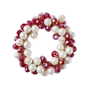 Close-up of burgundy faceted beads and white pearls on elastic hair tie for ponytails