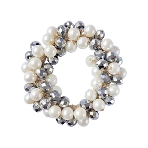 Detail of elastic hair tie with cream faux pearls and faceted dark grey metallic beads