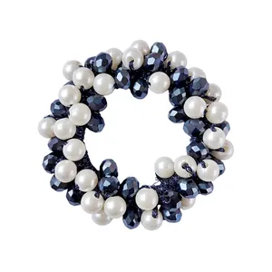 Detail of beaded hair tie with white pearls and black faceted crystals on elastic band