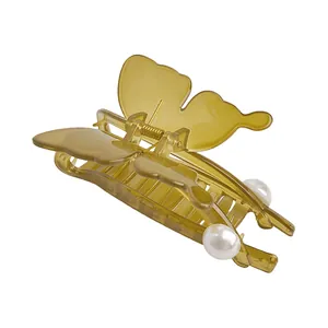 Detailed close-up of translucent butterfly hair claw clip with elegant pearl embellishment
