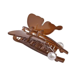 Transparent butterfly hair claw clip with pearl accents in amber brown for elegant styling