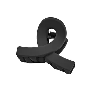 Detail of matte black hair claw clip featuring a sleek twisted cross design on white background