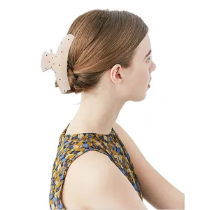 Pince à cheveux à pois pour chignon français élégant sur un fond blanc épuré