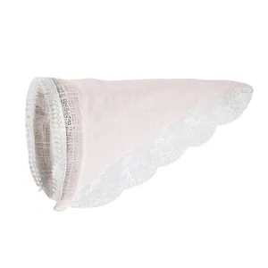 Dettaglio di cerchietto rosa chiaro in tessuto con pizzo bianco e decorazioni