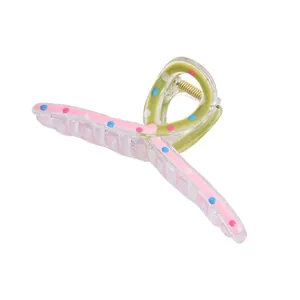 Vue détaillée de la pince à cheveux à pois avec panneaux roses et verts et ressort doré