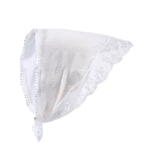 Détail d'un bandana en dentelle vintage blanche avec plis et bords fleuris brodés