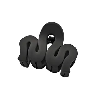 Detail of a black wavy matte hair claw clip featuring a metal spring on white background