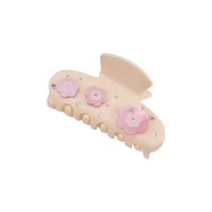 Elegant cream hair claw clip with pink floral motifs and sparkling rhinestone accents