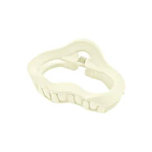 Detailed close-up of a matte cream white hair claw clip with a wavy hollow design