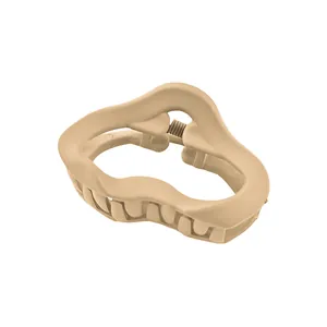 Close-up of matte cream-colored wavy hair claw clip with durable metal spring