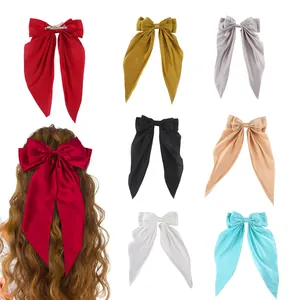 Close-up of large satin bow hair clips in seven elegant colors with metal spring clips